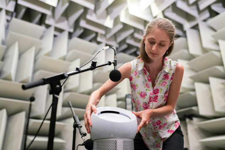 Female engineer working with sound equipment in anechoic chamber, showcasing sound testing and technology.